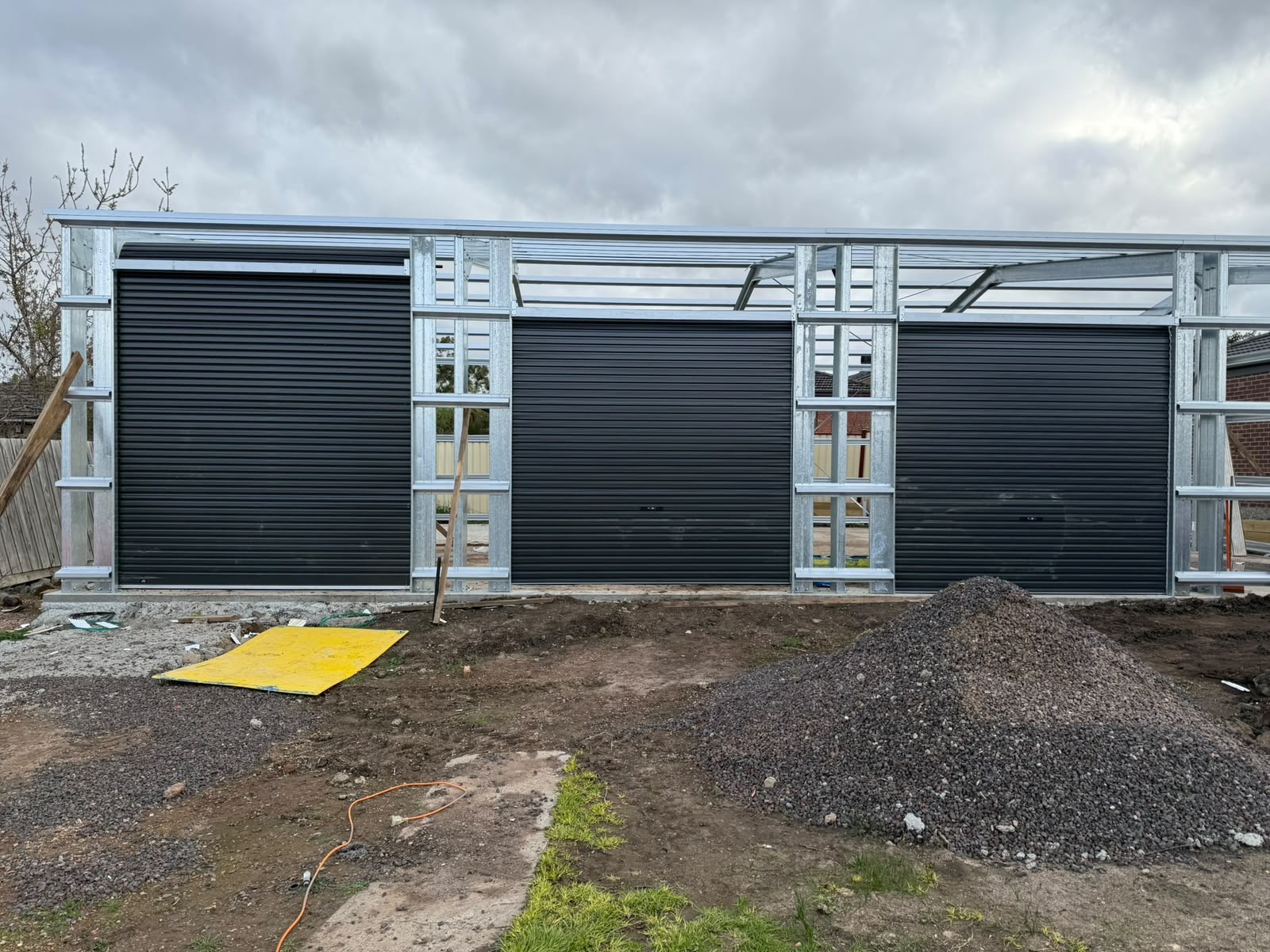 Triple black roller doors on new build garage
